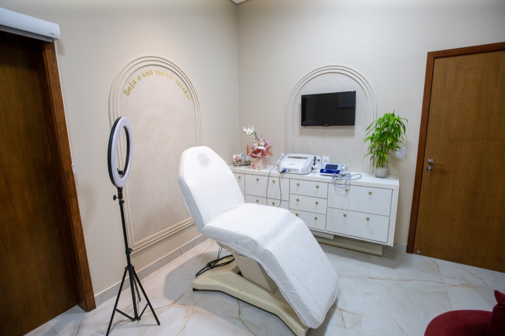 Sala de estética com maca, arcos decorativos e a frase Seja a sua melhor versão